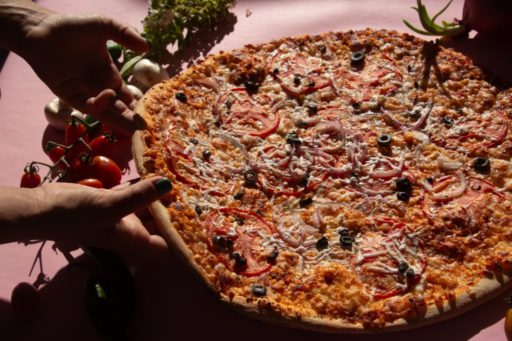 Person holding a pizza
